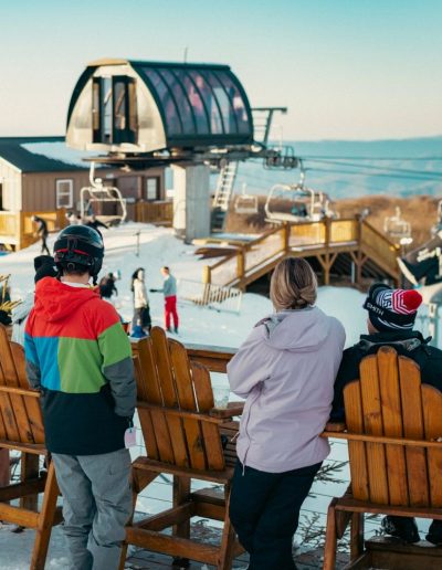 People watching snow skiers and snowboarders on slopes at ski resort in Beech Mountain, Nc.