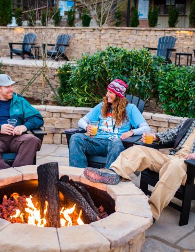 People sitting by fire pit at ski resort in Beech Mountain, NC.