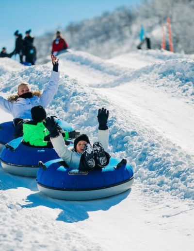 Kids snow tubing down snow tubing hill at Beech Mtn near Boone, NC.