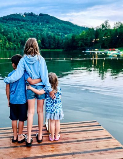 Family overlooking lake inflatables at campground near Asheville, NC.