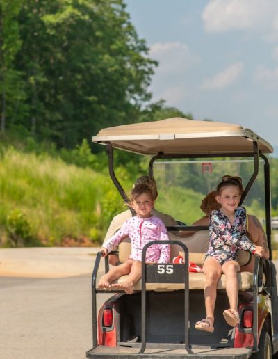 Kids riding on golf cart rental at Jellystone Campground in Bostic, NC.