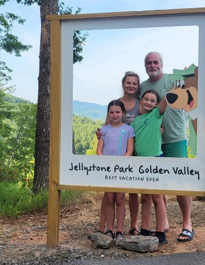 Family posing in front of mountain at Jellystone Campground near Asheville, NC.