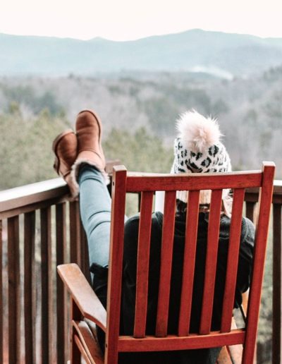 Woman on cabin rental porch looking at mountains in western, NC.