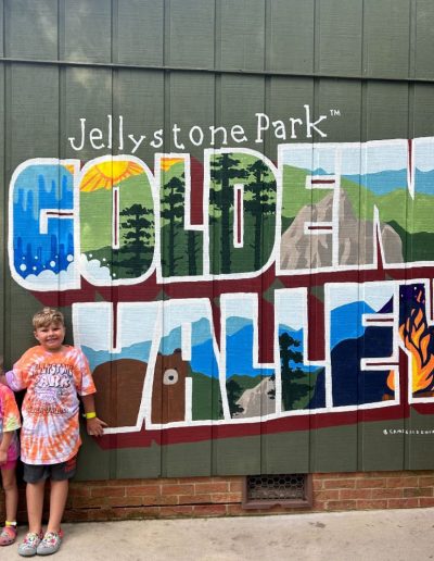 Kids next to campground sign of Jellystone Campground in Golden Valley.