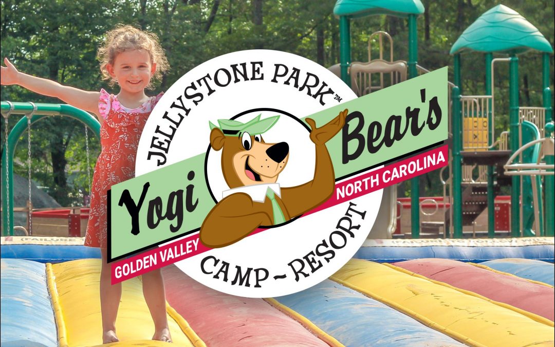 Kid on jumping pillow in front of playground at Yogi Bear campground near Charlotte, NC.