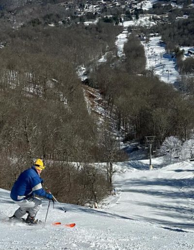 Man snow skiing down hill at Sugar Mountain resort in Sugar Mountain, NC.