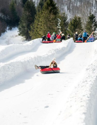 Person snow tubing at snow tubing park in Boone, NC.