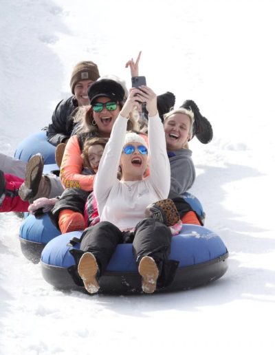 People snow tubing down snow tubing hill at Hawksnest near Charlotte, NC.