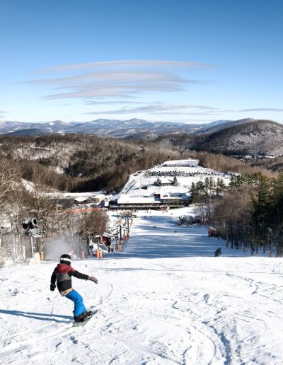 Person snowboarding down slope at ski resort near Boone, NC.