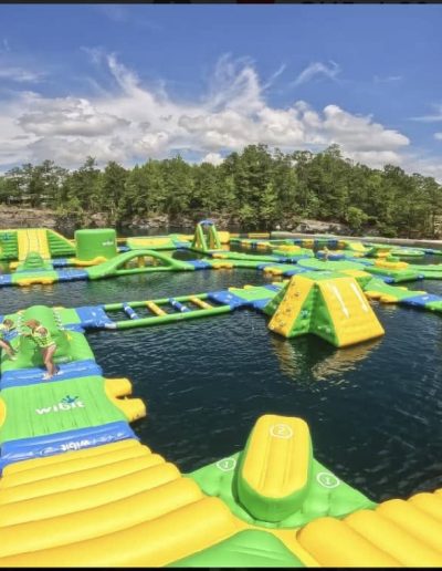 Kids climbing and sliding on the floating water park at Fantasy Lake NC