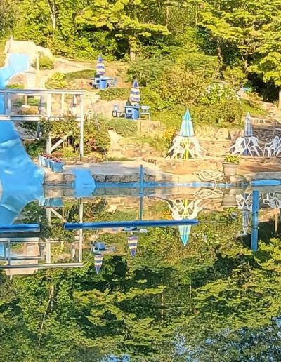 Outdoor swimming pool surrounded by trees and foothills at Sun Crest Water Park