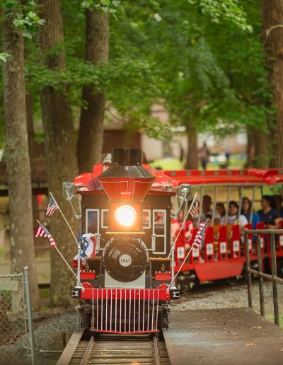 Burlington City Park train carrying passengers through the woods.