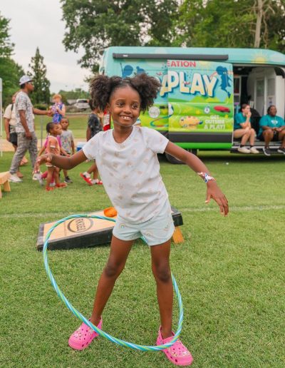 Girl hula-hooping during a community event at Burlington City Park.