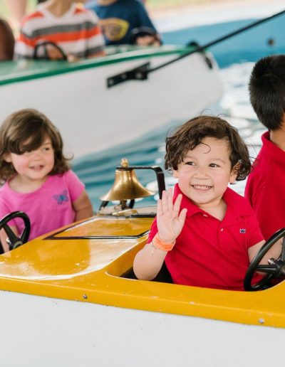 Children riding the kiddie boat attraction at Burlington City Park.