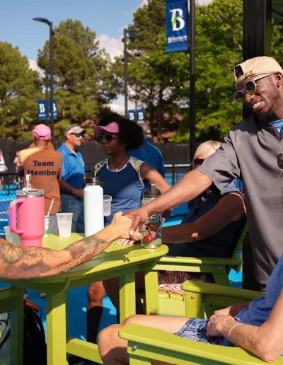 Visitors socializing beside the Burlington City Park pickleball courts.