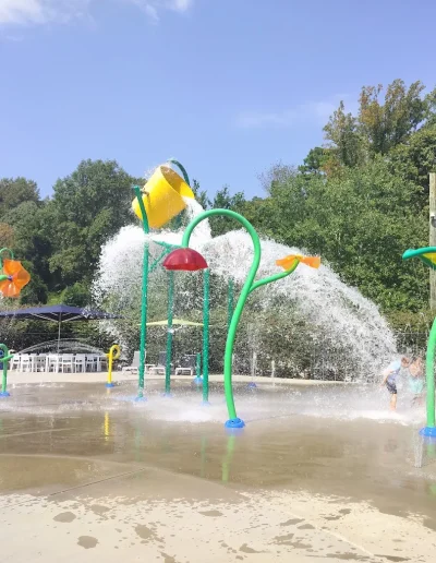 Children playing among large water sprayers at Burlington Splash Park.