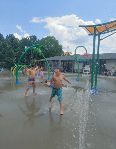Boy running through water jets at Burlington Splash Park.