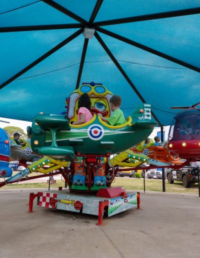 Colorful helicopter ride beneath a shade canopy at Burlington City Park.