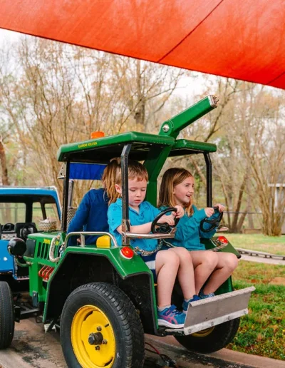 Children riding tractor-style vehicles at Burlington City Park.