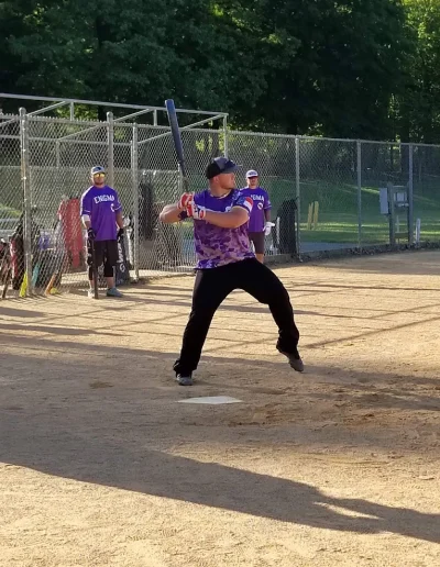 Softball player batting on a field at Burlington City Park.