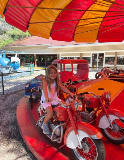 Child sitting on a motorcycle ride at Santa’s Land in Cherokee, NC