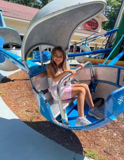 Child sitting in a blue helicopter ride at Santa’s Land in Cherokee, NC