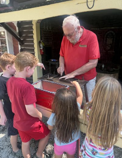 Children watching a craftsman demonstrate his work at Santa’s Land in Cherokee, NC