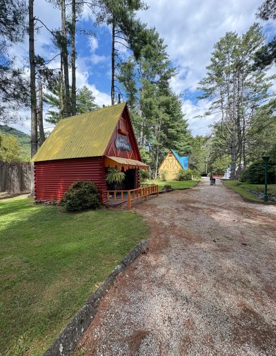 Rustic red cabin along a wooded park path at Santa’s Land in Cherokee, NC