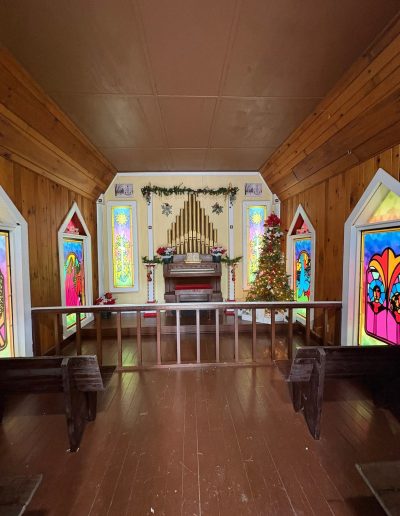 Christmas-decorated chapel interior with stained-glass windows at Santa’s Land in Cherokee, NC