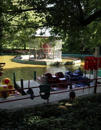 Pedal boats docked beside a tree-shaded lake at Santa’s Land in Cherokee, NC