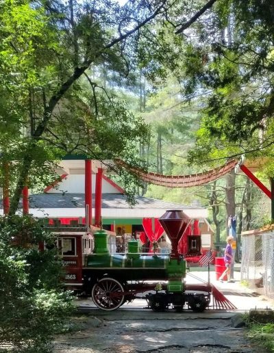 Santa’s Express locomotive passing park buildings in Cherokee, NC