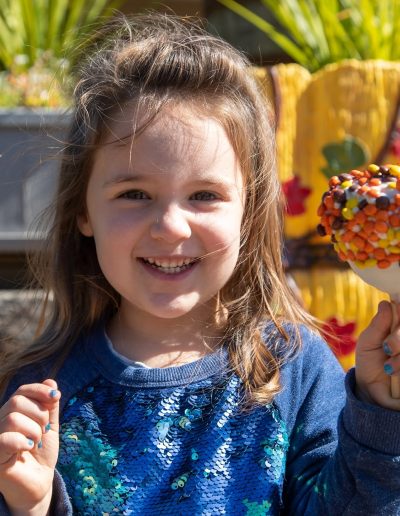 Young visitor holding a caramel apple at Tweetsie Railroad
