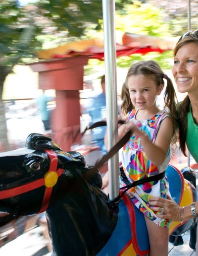 Parent and child riding the carousel at Tweetsie Railroad