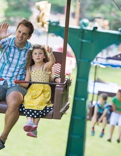 Family waving from the Tweetsie Railroad chairlift