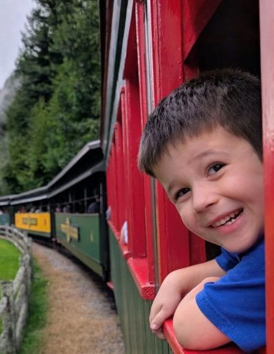 Boy looking from a red Tweetsie Railroad train car