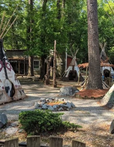 Decorated tipis beneath tall trees at Deadwood near Williamston, NC