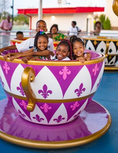 Children riding in a purple teacup at Frankie's of Charlotte in Huntersville, NC.