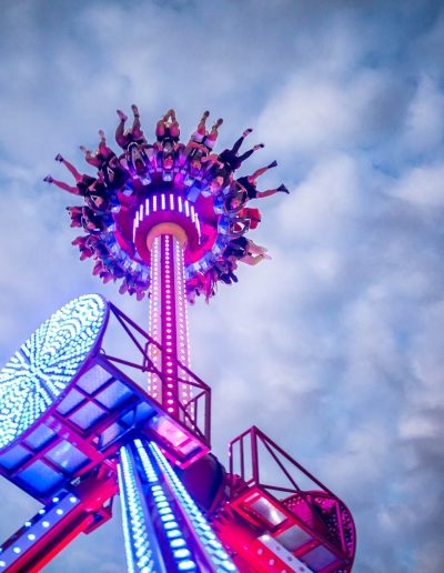 Discovery thrill ride glowing purple at dusk at Frankie's of Charlotte in Huntersville, NC.