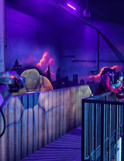 Players aiming inside a neon-lit laser tag arena at Frankie's of Charlotte in Huntersville, NC.
