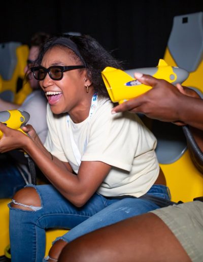 Guests holding yellow controllers on an indoor motion ride at Frankie's of Charlotte in Huntersville, NC.