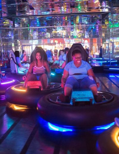 Riders driving glowing indoor bumper cars at Frankie's of Charlotte in Huntersville, NC.