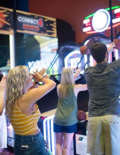 Friends shooting baskets at an arcade game at Frankie's of Charlotte in Huntersville, NC.