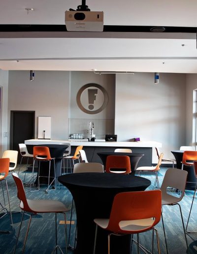 Private event room with tables and a projector at Frankie's of Charlotte in Huntersville, NC.