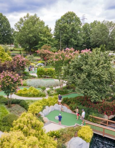 Mini-golf greens among trees and footbridges at Frankie's of Charlotte in Huntersville, NC.